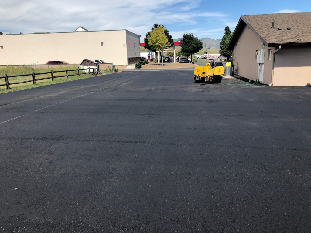 Heavy machinery smoothing out asphalt during a routine pavement repair.